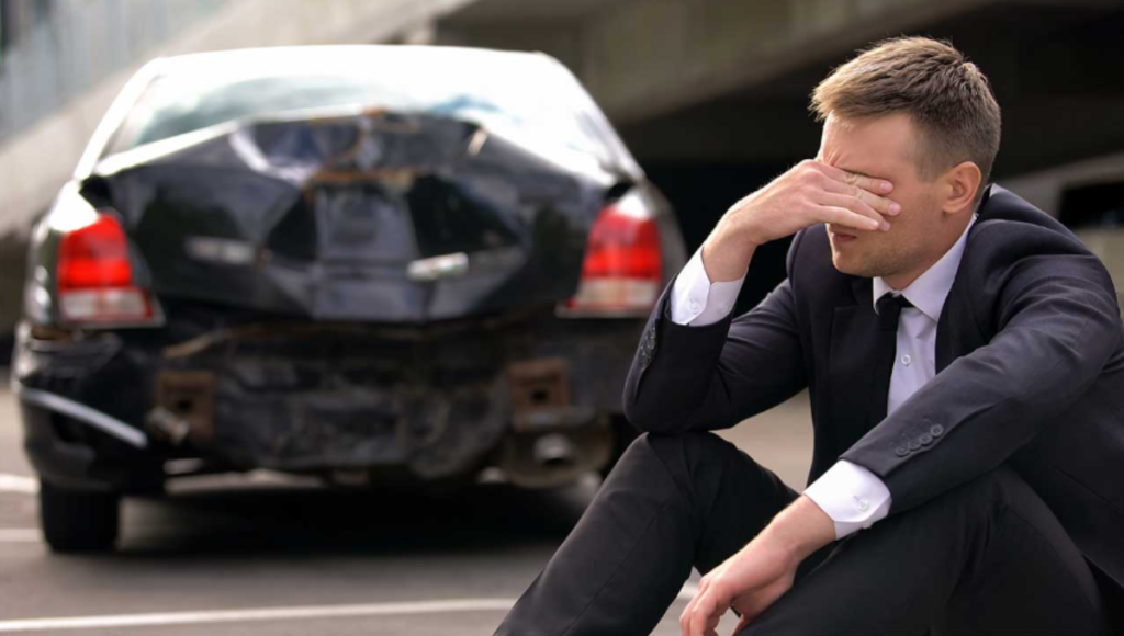 Auto accident attorney reviewing a crash scene photo and medical bills at a desk