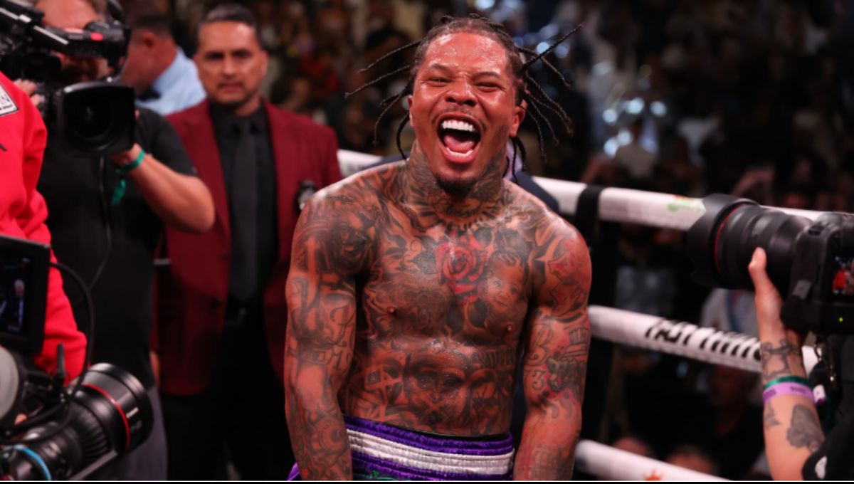 Gervonta “Tank” Davis in black trunks launching a left uppercut under arena lights