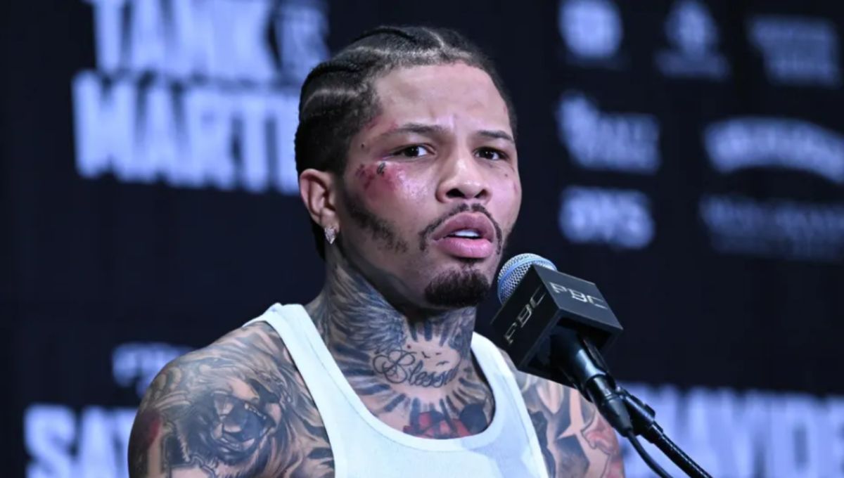 Gervonta “Tank” Davis in black trunks launching a left uppercut under arena lights