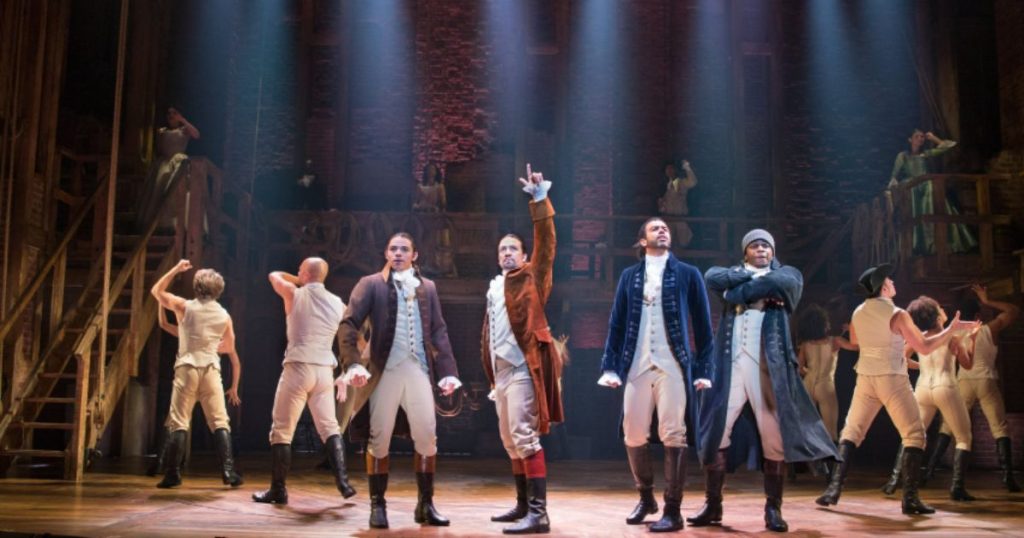 Hamilton logo projected on a large cinema screen with audience silhouettes