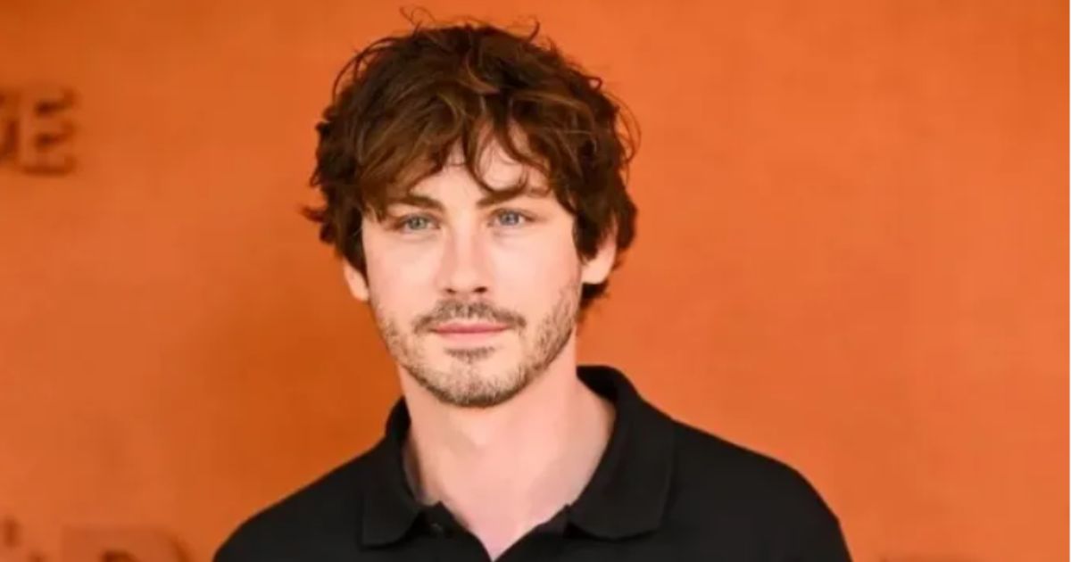 Logan Lerman posing at a movie premiere in formal attire with a calm, confident expression