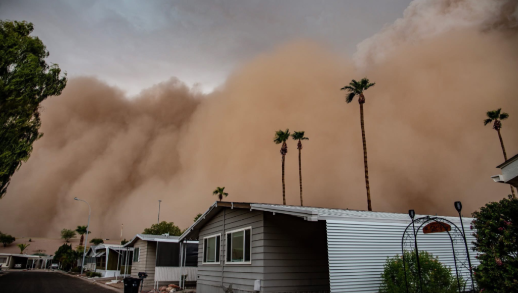 Towering wall of dust rolling over Phoenix Sky Harbor as aircraft and terminals disappear into brown haze