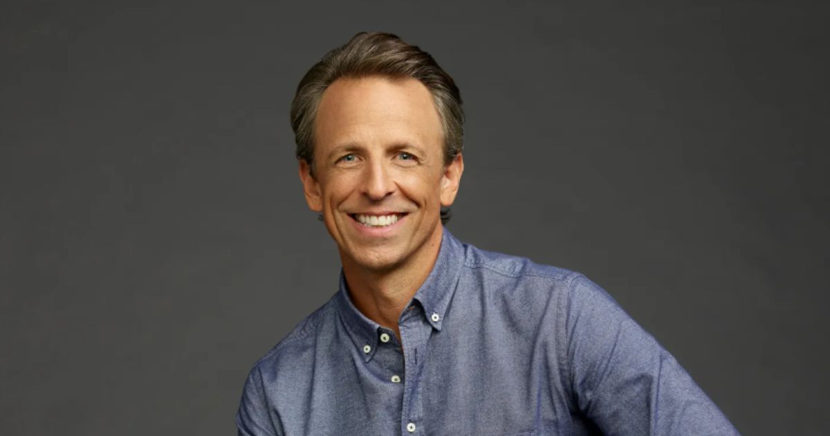 Seth Meyers performing behind his desk on Late Night, smiling in 2025