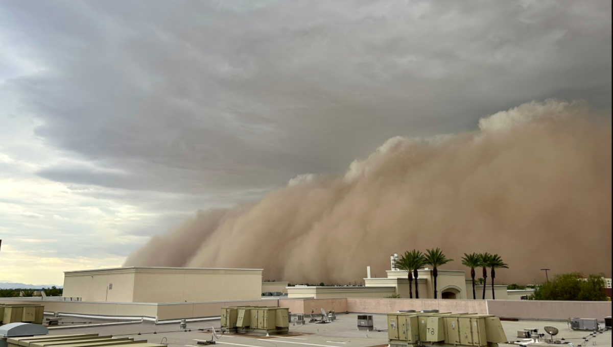 Towering wall of dust rolling over Phoenix Sky Harbor as aircraft and terminals disappear into brown haze