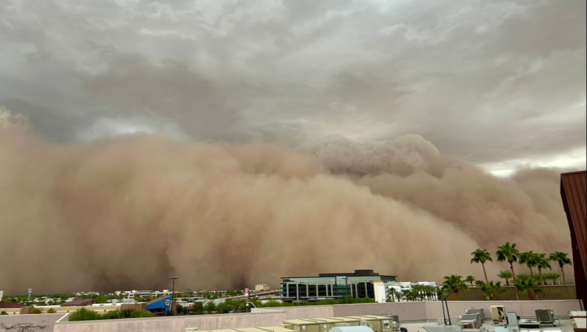 Towering wall of dust rolling over Phoenix Sky Harbor as aircraft and terminals disappear into brown haze