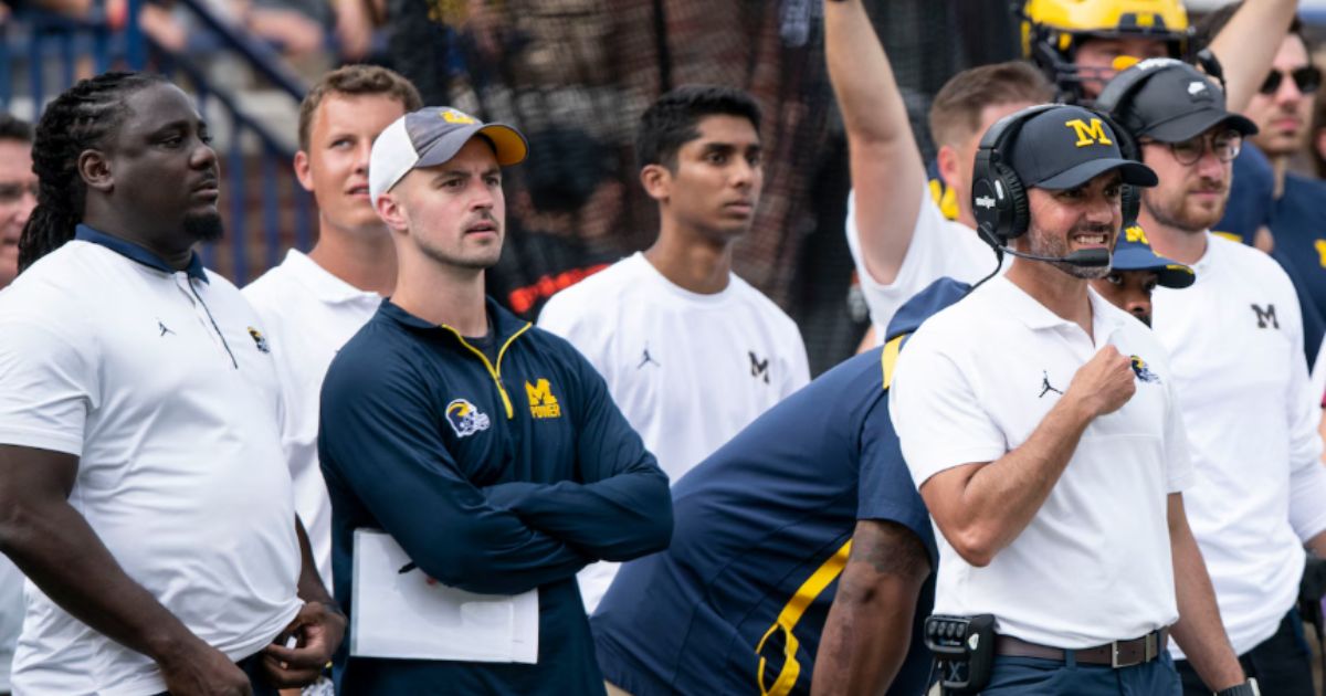 University of Michigan Wolverines football baring the NCAA logo with a gavel and penalty icons in the background
