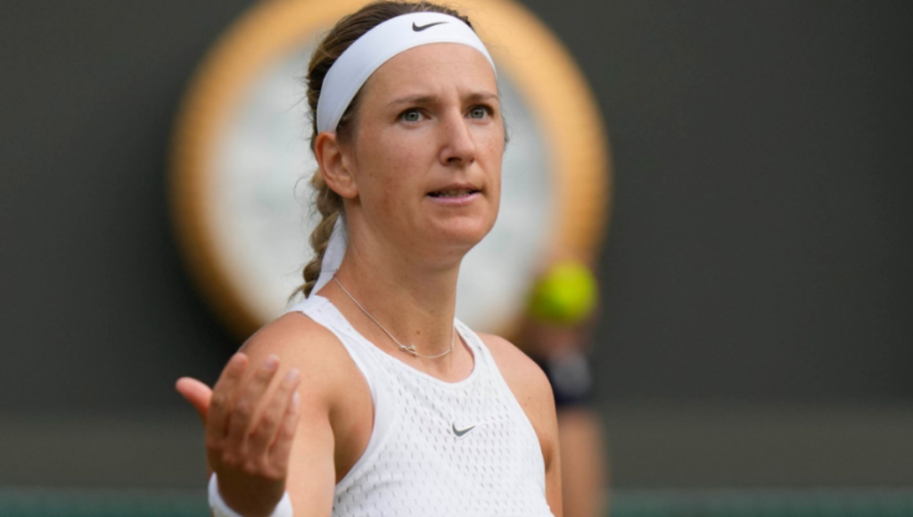 Victoria Azarenka fist pumps on a hard court after winning a US Open match under bright lights