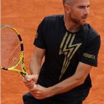 Adrian Mannarino hitting a forehand on grass during Wimbledon 2025