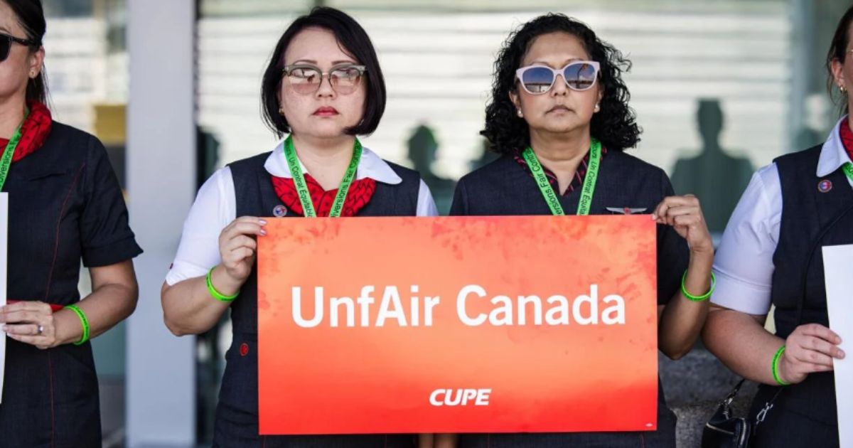 Air Canada flight attendant picketing outside the terminal with a stop sign demanding fair pay in 2025