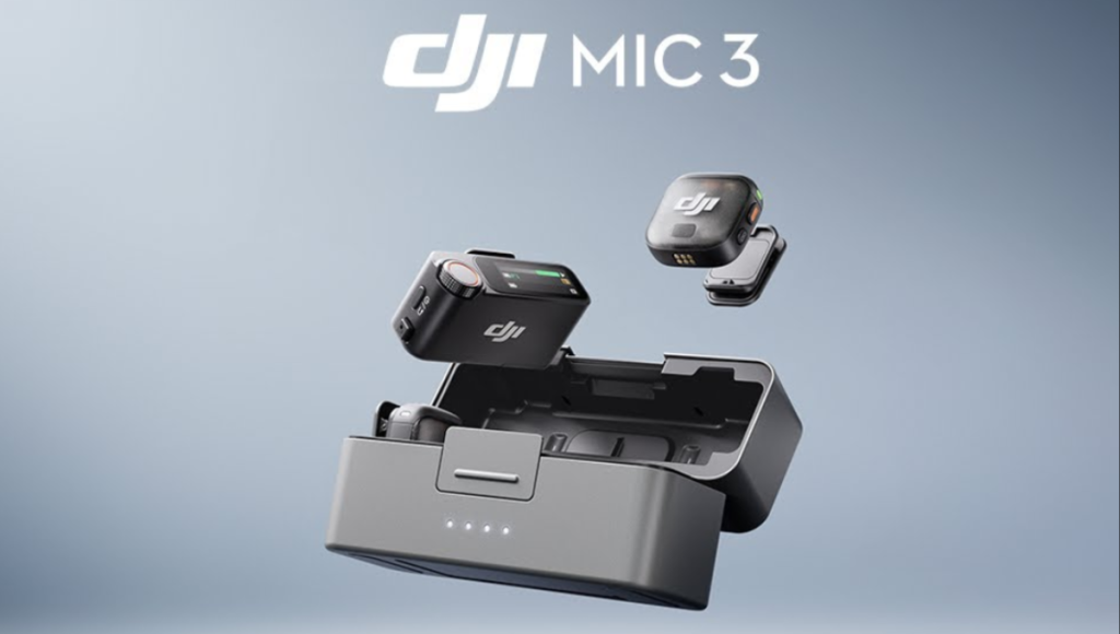 DJI Mic 3 transmitter, receiver, and charging case on a desk with camera gear in the background