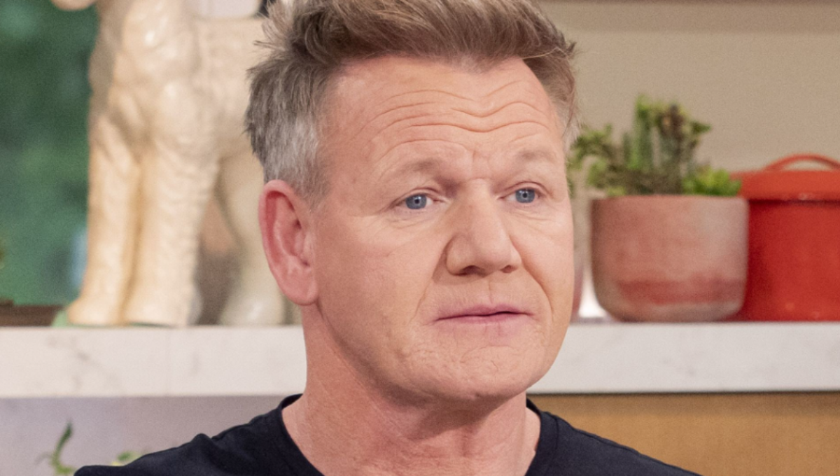 Gordon Ramsay smiling at a TV set kitchen, with soft lighting on his face