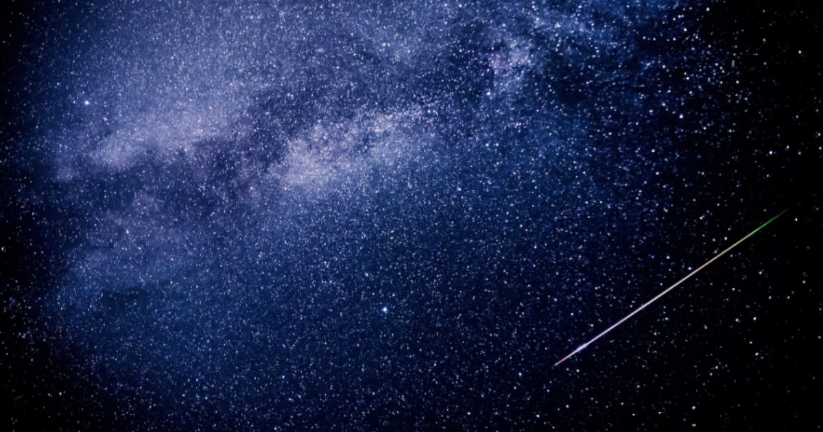 Perseids meteor shower streaks across night sky over a rural dark horizon