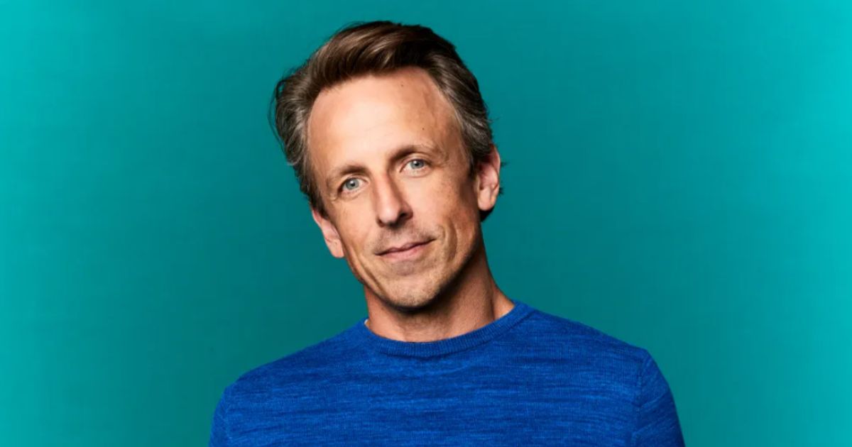 Seth Meyers performing behind his desk on Late Night, smiling in 2025