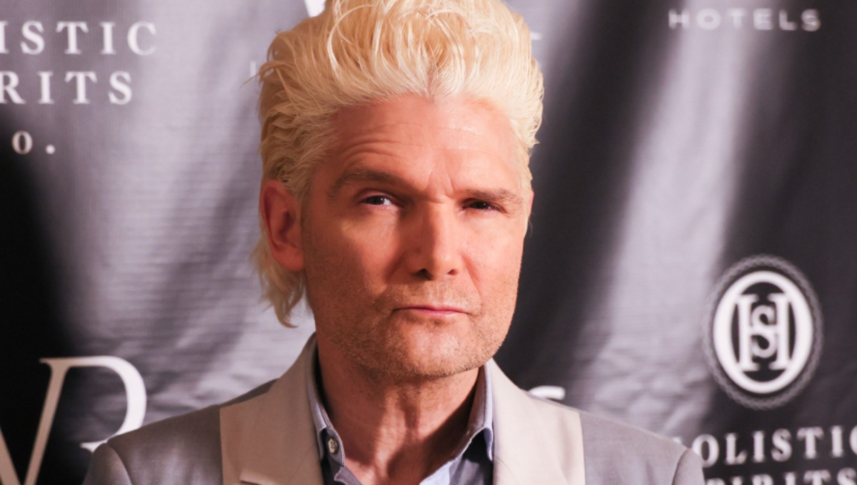 Corey Feldman performing on stage with spotlight and microphone