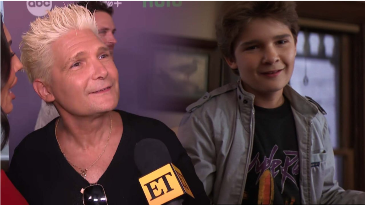 Corey Feldman performing on stage with spotlight and microphone