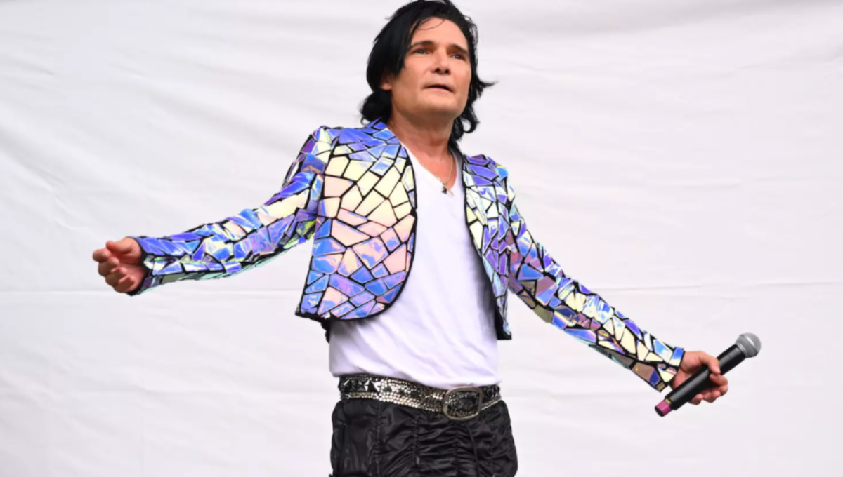 Corey Feldman performing on stage with spotlight and microphone