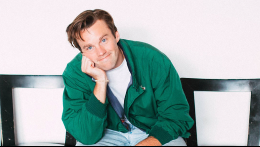 Tommy Brennan on stage at SNL, smiling as he performs a live sketch