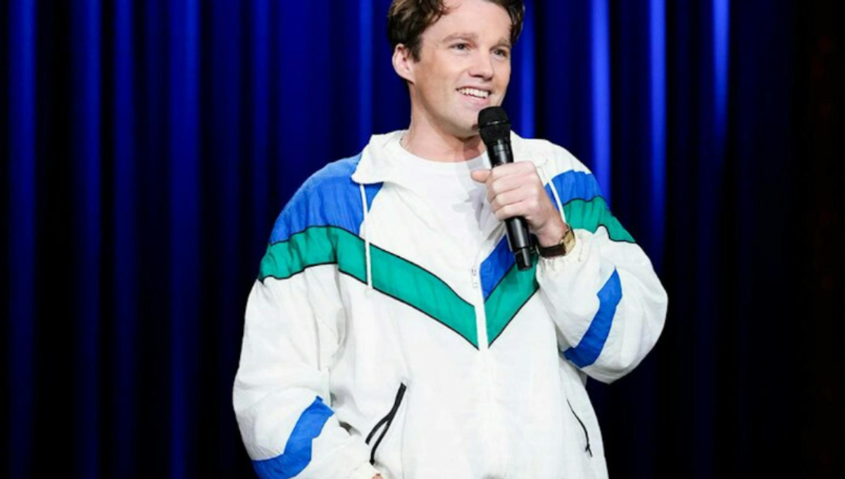 Tommy Brennan on stage at SNL, smiling as he performs a live sketch
