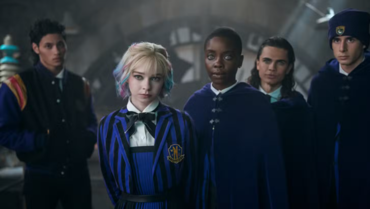 Jenna Ortega as Wednesday Addams staring forward in a gothic academy hallway, symbolic of a new season
