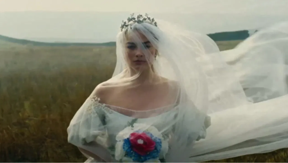 Poster-style image of Margot Robbie and Jacob Elordi as Catherine Earnshaw and Heathcliff on a windswept moor at dusk