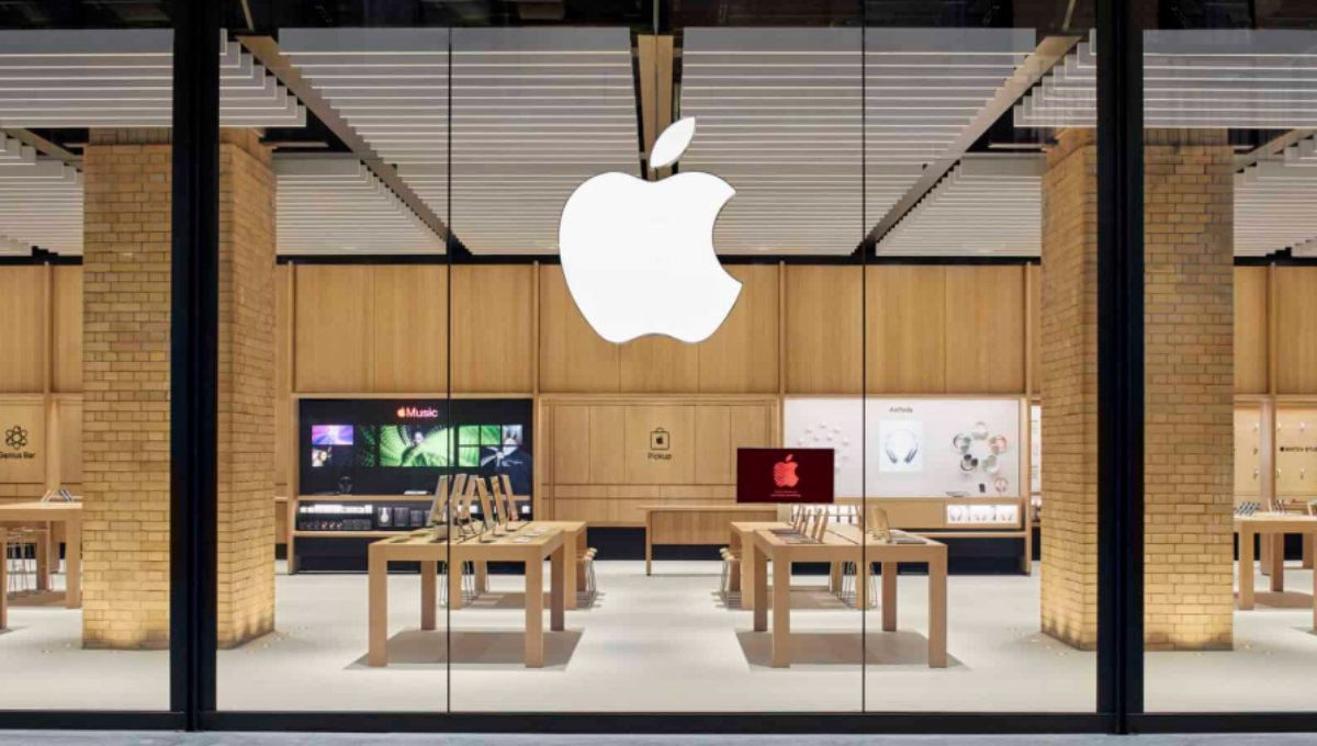 Exterior of a modern Apple Store with glass facade and customers gathering outside at dusk