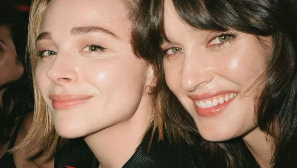 Kate Harrison in a custom Louis Vuitton bridal look, smiling beside Chloë Grace Moretz after their ceremony