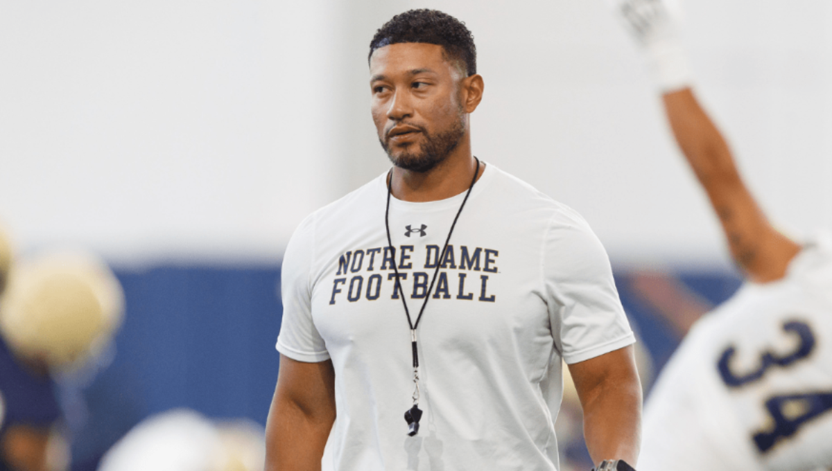 Marcus Freeman on the Notre Dame sideline addressing players during a timeout