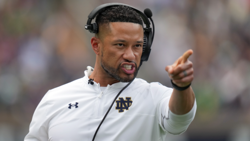 Marcus Freeman on the Notre Dame sideline addressing players during a timeout