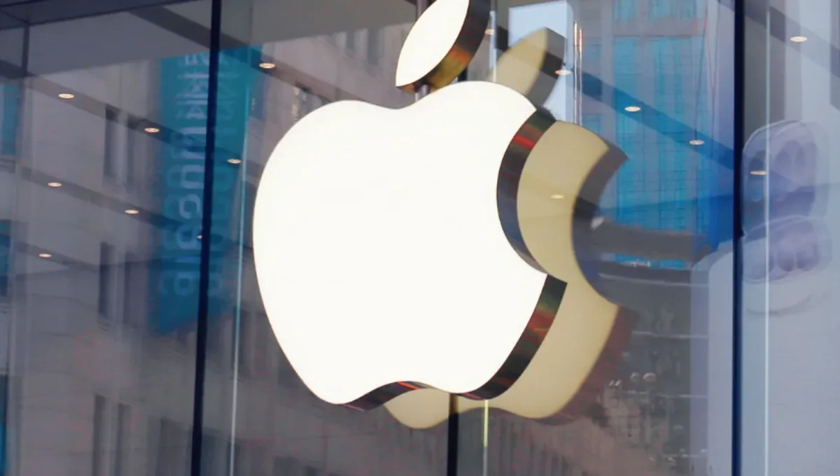 Exterior of a modern Apple Store with glass facade and customers gathering outside at dusk